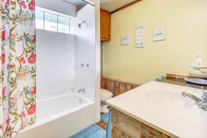 a bathroom with a tub and a sink and a toilet at Walk to Lake Buchanan Cottage Near Wineries! in Buchanan Dam +16 photos