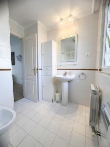 a white bathroom with a sink and a mirror at Apartamento en la playa de Mogro con parking privado in Mogro