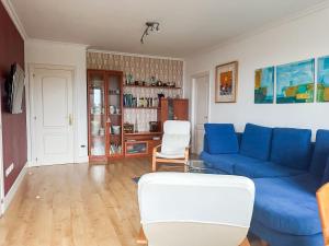 a living room with a blue couch and chairs at Apartamento en la playa de Mogro con parking privado in Mogro