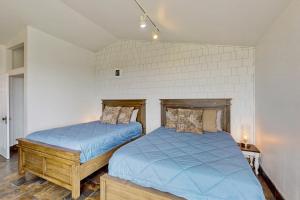 2 letti con lenzuola blu in una camera da letto di Westport Waves Beach House a Westport