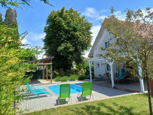 ein Hinterhof mit einem Swimmingpool und einem Haus in der Unterkunft Oliva 8 fős Balatoni Nyaraló in Balatonakarattya + 17 Fotos