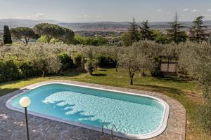una piscina en un patio con un huerto de manzanas en Villa Ballodole, en Florencia