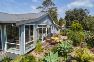 a small house with a deck and a patio at Valhalla North & Northern Lodge - waterfront, rural, semi-isolated in Kerikeri