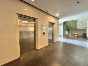 a lobby with a elevator and a table in the distance at Urban Boho Oasis1 Studio With Balcony in Davao City