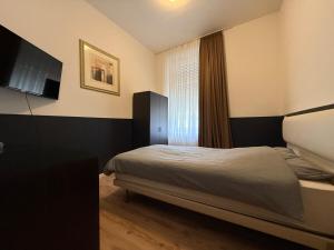 a small bedroom with a bed and a window at Cici Monteurunterkünfte Altena City Wohnung für Handwerker in Altena