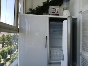 a white refrigerator with its door open next to a window at Ryan S3 in Fès