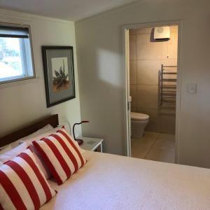 a bedroom with a bed and a bathroom with a shower at Valhalla North & Northern Lodge - waterfront, rural, semi-isolated in Kerikeri