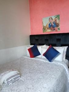 a bed with four pillows and a painting on the wall at Ryan S3 in Fès