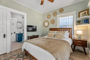 a bedroom with a large bed and a television at Timeless Charm by the Coast, Vintage Beach Bungalow in Long Beach +23 photos