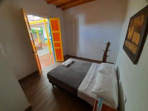 ein Schlafzimmer mit einem Bett und einer offenen Tür in der Unterkunft ECOXPLORA-Casa de campo in Jardin