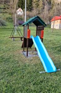 a playground with a slide in a field at Princess Jana Apartments in Selišta
