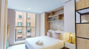 Un dormitorio con una cama y una ventana grande. en SecreT Top 85, en Bogotá