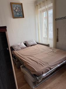 an empty bed in a room with a window at Daghsen in Nice