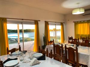 a dining room with a table and chairs and windows at Esquina Lodge in Esquina +8 photos
