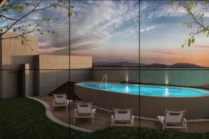 a pool on the roof of a building with chairs at Studio Sabana Secrt 3011 in San José