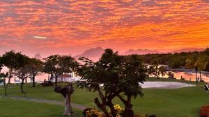 a sunset over a park with trees and a river at Grenade 21 vue mer proche plage dans Complexe type Village Vacances in Sainte-Luce