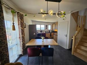 a dining room and kitchen with a wooden table and chairs at Cozy Family in Angers