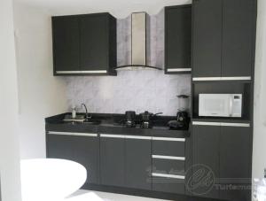 a kitchen with black cabinets and a microwave at Condomínio CTC Araras, Caldas Novas - VPC in Caldas Novas +74 photos