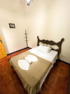 a bedroom with a bed with two towels on it at Casa Rústica da Rua do Carmo - Diamantina - MG in Diamantina