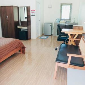 Un dormitorio con una cama, un escritorio y una mesa. en First Light beach bungalow 3, en Ko Pha Ngan