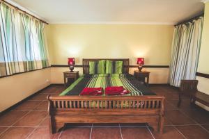 a bedroom with a bed with two night stands at Gîte Domaine de la Ferme d'Erambere lot 67 route de la Nondoue in Dumbéa