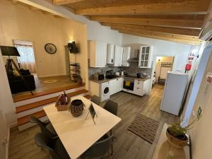 a kitchen with a table and a kitchen with white appliances at Alqueive GUEST HOUSE in Alqueva