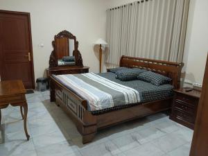 a bedroom with a bed and a dresser and a mirror at Siloyo Homestay - Hommy place to stay! in Sasak Dua