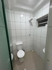 a white bathroom with a toilet and a sink at Cruz De MaIta Hotel in Sao Paulo