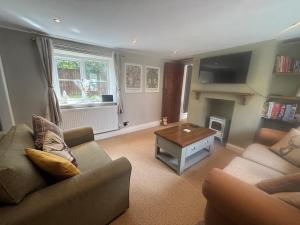 a living room with a couch and a coffee table at The Corner Cottage in Wotton-under-Edge