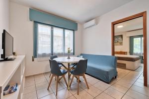 a living room with a table and chairs and a bedroom at Ginestra Deluxe Idromassaggio privato e piscina in Eraclea Mare +13 photos