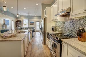 eine Küche mit weißen Schränken und einer Arbeitsplatte in der Unterkunft Watercolor Bungalow TC 2101 in Port Aransas