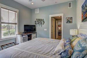 ein Schlafzimmer mit Bett und Flachbildfernseher in der Unterkunft Watercolor Bungalow TC 2101 in Port Aransas + 27 Fotos
