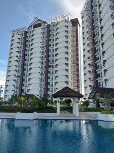 un grand immeuble d'appartements avec un kiosque en face de celui-ci dans l'établissement Royal Ocean Crest Mactan- 5R Staycation 1110C, à Lapu Lapu City