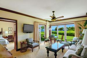 a living room with a couch and a tv at Waipouli Beach Resort Exquisite Ocean Front Condo in Oceanfront H Building Sleeps 8 AC Pool in Kapaa