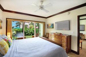 a bedroom with a bed and a flat screen tv at Waipouli Beach Resort Exceptional Condo Pool View Condo in Kapaa