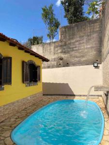 a swimming pool with a fountain in front of a house at Casa no centro de Miguel Pereira in Miguel Pereira