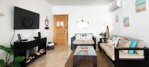a living room with a couch and a table at AMAR'E beach front apartment overlooking pool in Las Terrenas