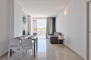 a living room with a table and chairs and a couch at Magnolie Suite Bella vista a 2 passi dal mare in Eraclea Mare +12 photos