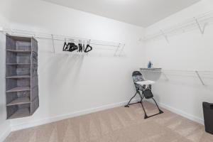 a white room with a chair and a shelf at King and Queen 2-Story Loft with 2 Ensuite Baths and Private Balcony at Atlantic Station in Atlanta +26 photos