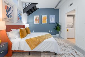 a bedroom with a large bed with yellow pillows at King and Queen 2-Story Loft with 2 Ensuite Baths and Private Balcony at Atlantic Station in Atlanta