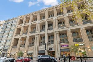 a large building with cars parked in front of it at King and Queen 2-Story Loft with 2 Ensuite Baths and Private Balcony at Atlantic Station in Atlanta