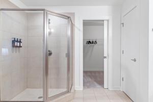 a shower with a glass door in a bathroom at King and Queen 2-Story Loft with 2 Ensuite Baths and Private Balcony at Atlantic Station in Atlanta