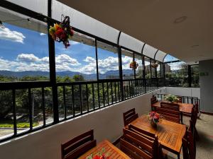a balcony with tables and chairs and a view of the mountains at Balcón Paisa SAS in Medellín