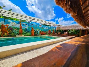 a swimming pool in a resort with a mural at Maya Dreams Bacalar in Bacalar