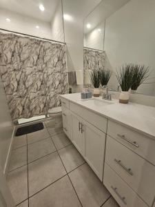 une salle de bain avec un lavabo, des toilettes et un miroir dans l'établissement genie palace at statefarm stadium, à Phoenix