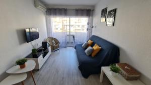a living room with a blue couch and a tv at Apartamento T1 centro Albufeira in Albufeira +23 photos