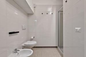 a white bathroom with a toilet and a sink at Magnolie A37, Vista & comfort vicino al mare in Eraclea Mare