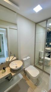 a bathroom with a toilet and a sink and a mirror at Apartamento Luxo Centro com Suíte, Sacada, Garagem, Garage in Jaraguá do Sul +16 photos