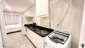 a small kitchen with a sink and a refrigerator at ASA | Lofts Zimmer BR470 in Gaspar