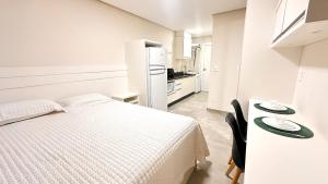 a white bedroom with a bed and a refrigerator at ASA | Lofts Zimmer BR470 in Gaspar